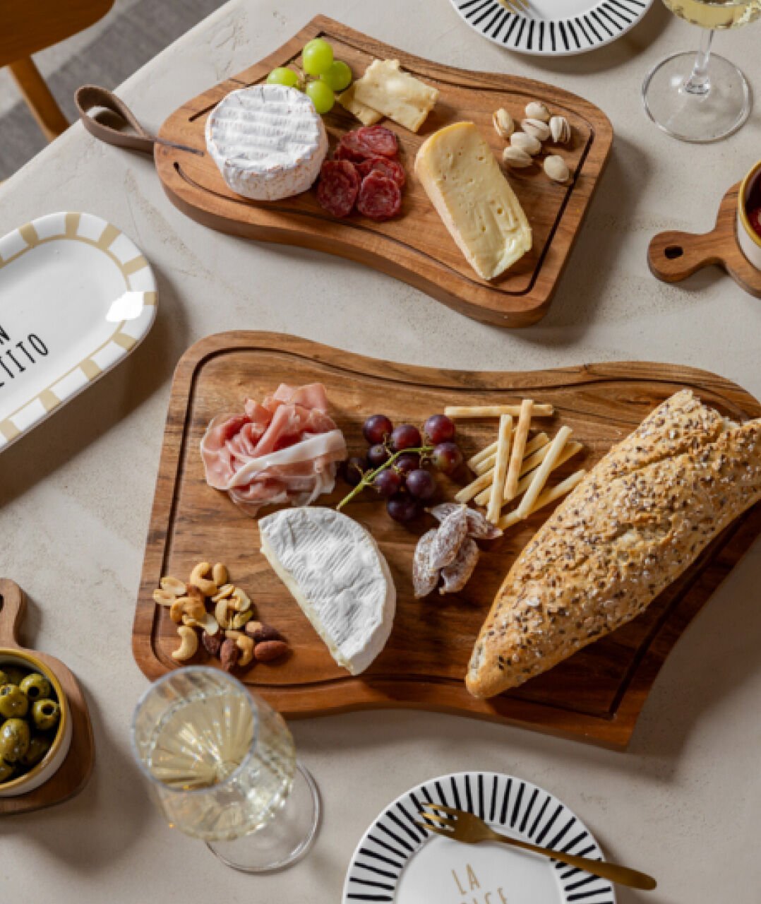 Een tafel 2 borrelplanken met daar kaas, worst en brood op