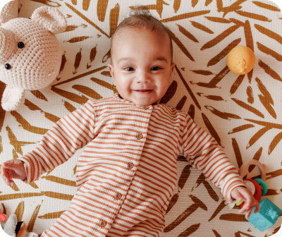 Een baby die op een speelkleed ligt