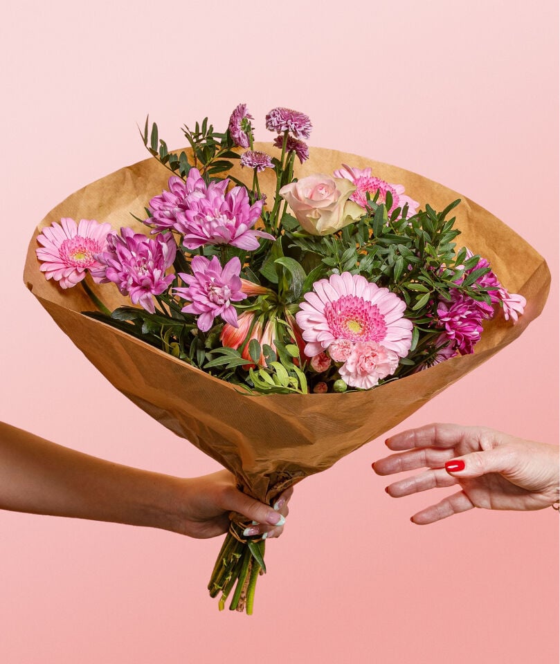 Een bos bloemen die aan iemand word gegeven