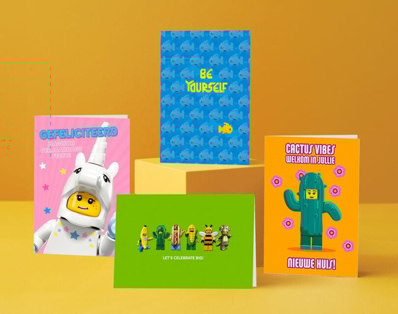 Een roze, blauwe, groene; en oranje legokaart met LEGO mannetjes op de voorkant van de kaarten.