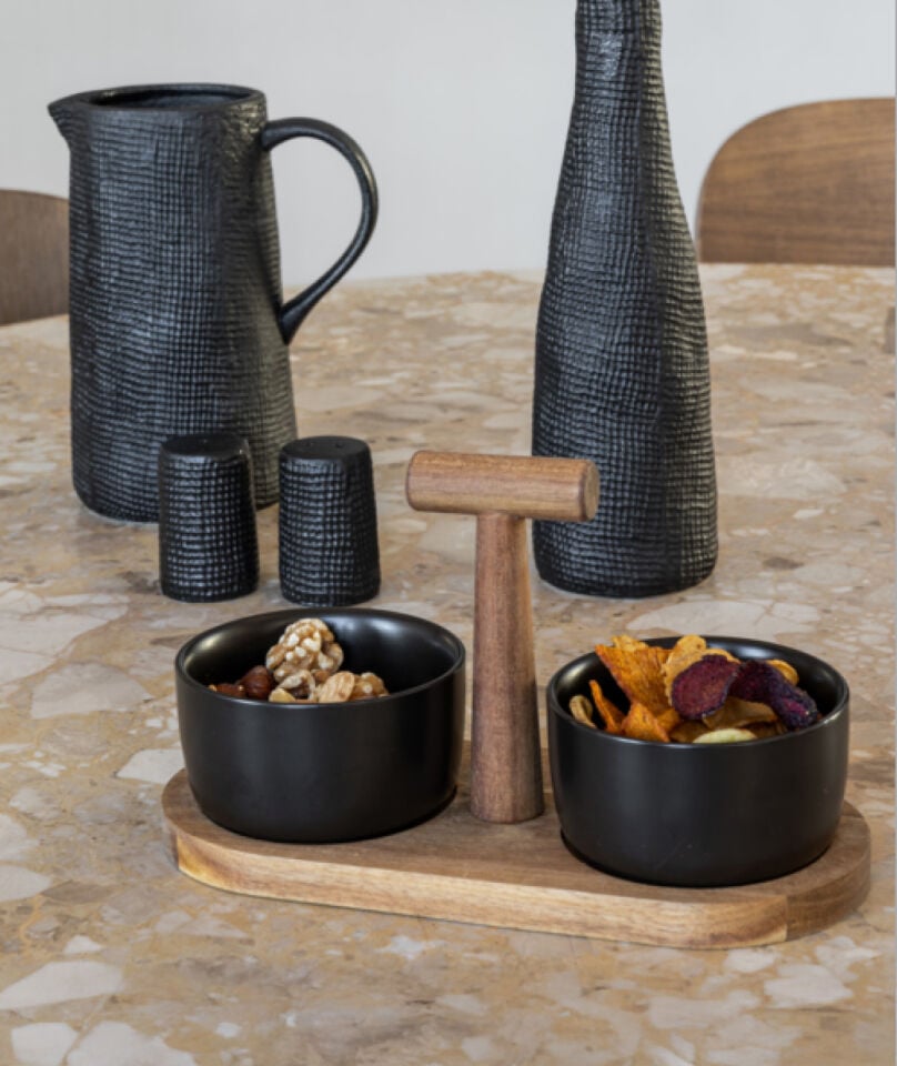 Twee kleine zwarte bakjes met snacks erin