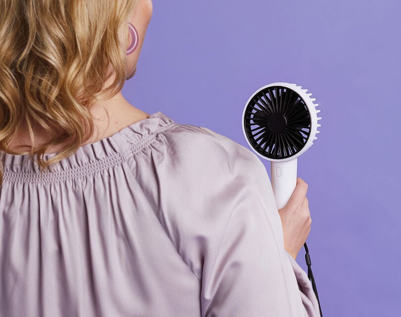 Een vrouw die een hand ventilator vasthoud