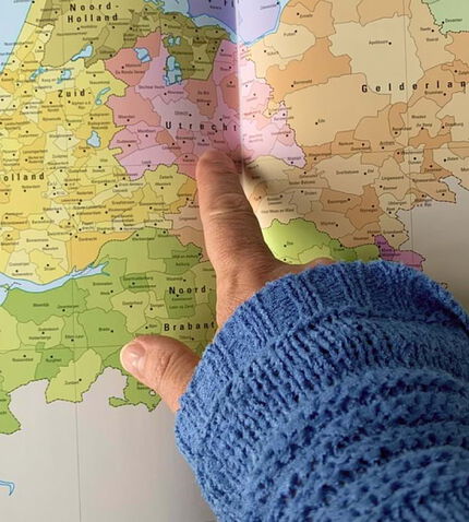 Hand die wijst naar een regio op een kaart van Nederland 
