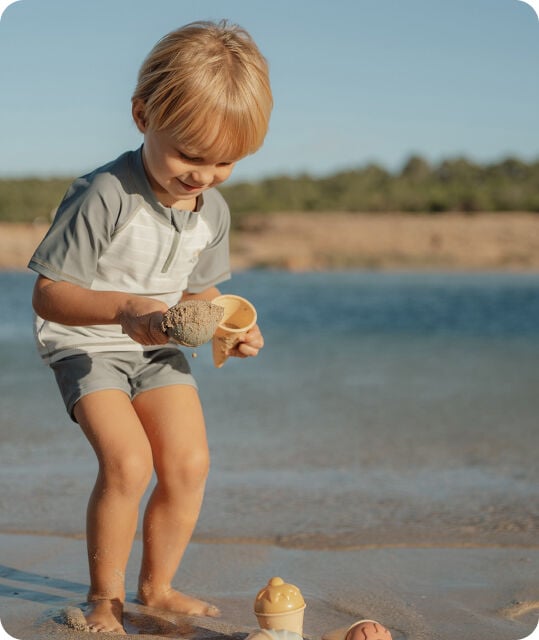Een kindje die op het strand aan het spelen is