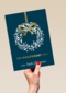 kerstkaart met krans op blauwe achtergrond